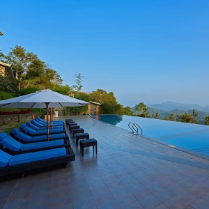 Luxury infinity swimming pool overlooking deep forest valleys at Poetree Resort Thekkady.