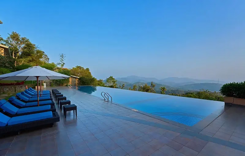 Premium hilltop cottage balcony with panoramic wilderness views at Poetree Resort Thekkady.