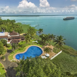 Large lakeside infinity swimming pool and manicured family recreation lawns at World Backwaters Resort.